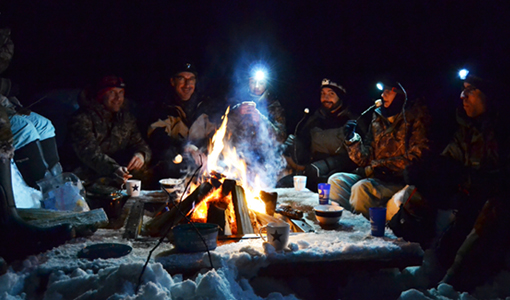 les retrouvailles autour du feu de camp durant un raid chien de traîneau en Laponie suédoise